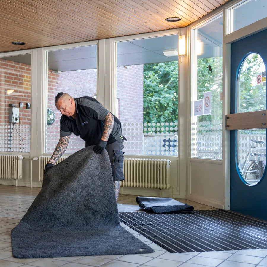 Een servicemedewerker van Lavans legt Effektmat Droogloopmat bij een klant neer