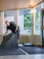 Een servicemedewerker van Lavans legt Effektmat Droogloopmat bij een klant neer