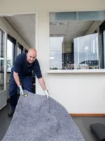 Een servicemedewerker van Lavans legt Effektmat Droogloopmat neer