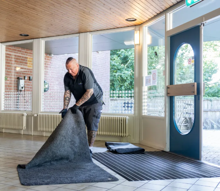 Een servicemedewerker van Lavans legt Effektmat Droogloopmat bij een klant neer
