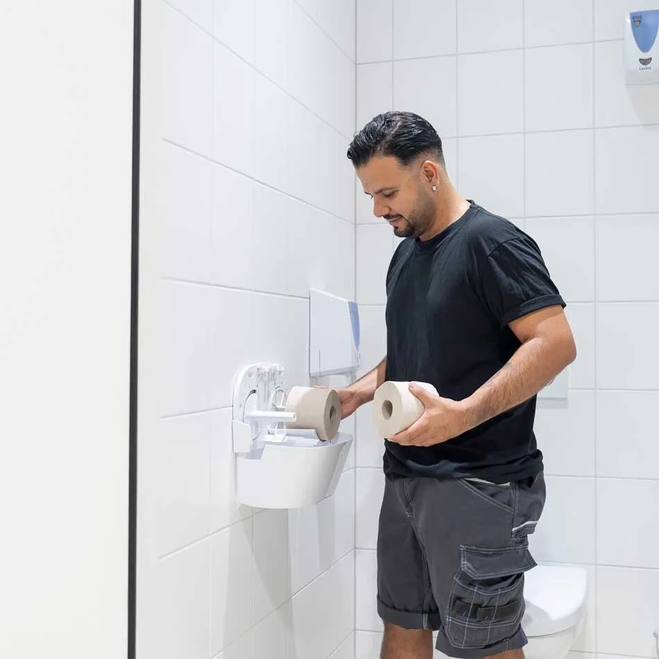 Servicemedewerker van Lavans vult wc-rollen aan