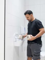 Servicemedewerker van Lavans vult wc-rollen aan