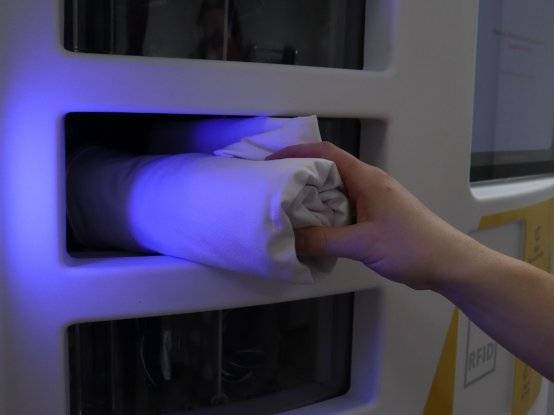 Medewerker pakt kleding uit de kledingkast